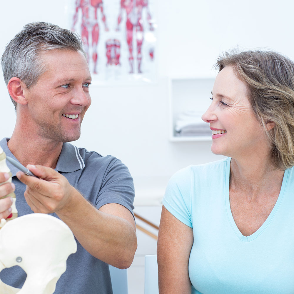 a male chiropractor consulting with a female patient