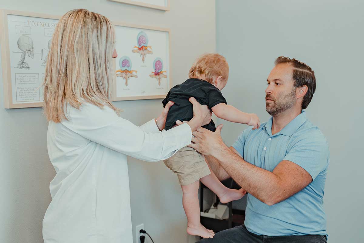 Pediatric chiropractor, Dr. Cody Drake, offering chiropractic care to young child